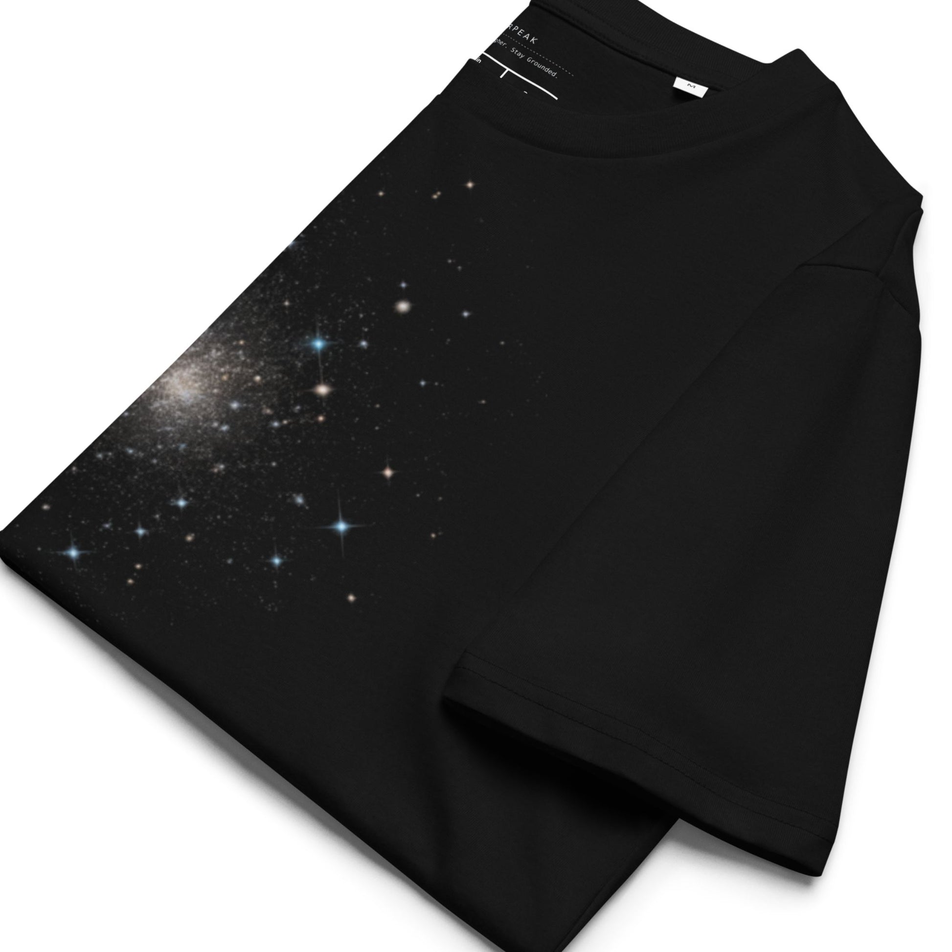 A folded black t-shirt with a starry sky design on a white background