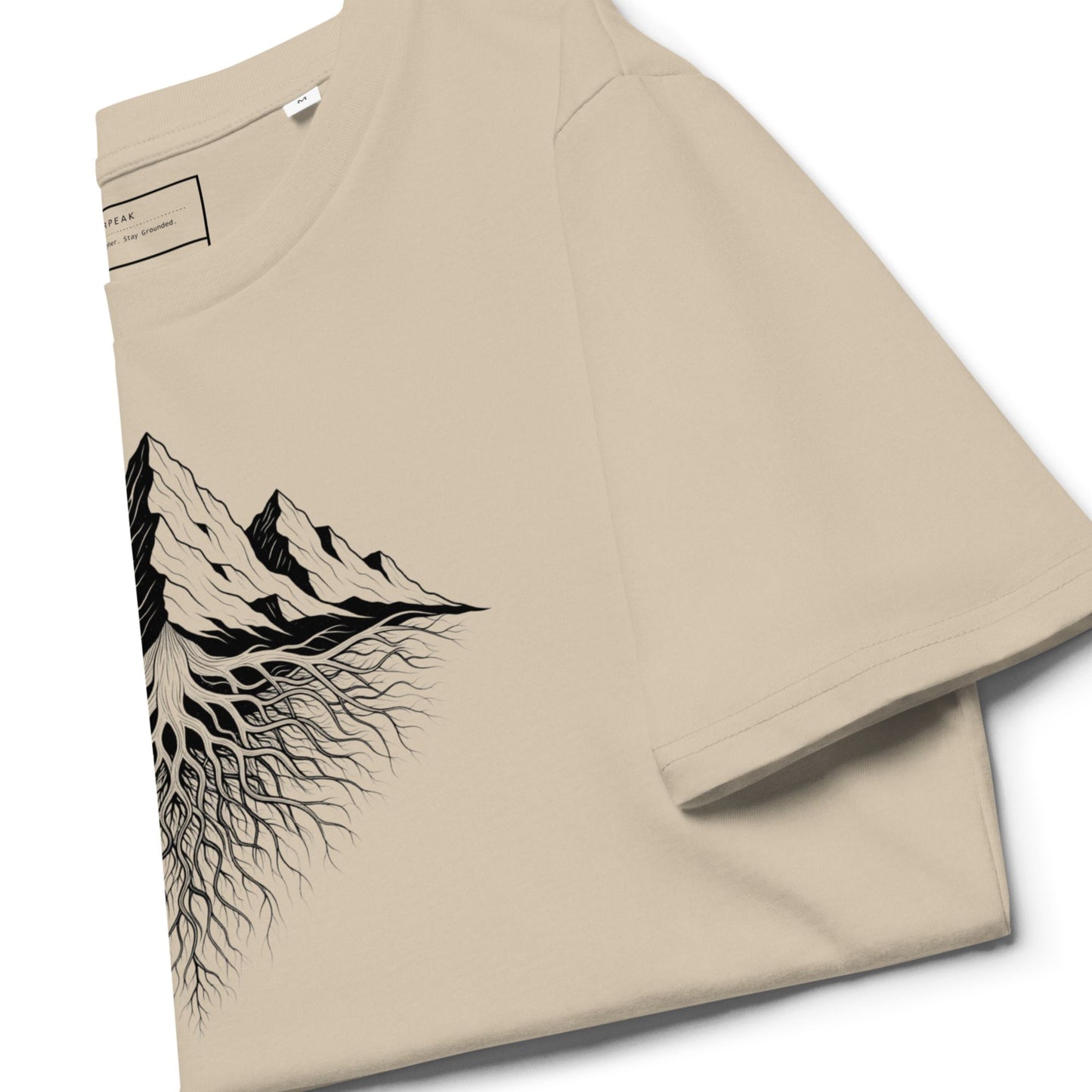 Aether Peak Roots organic t-shirt in Desert Dust, close-up of sleeve and black mountain-with-roots graphic.