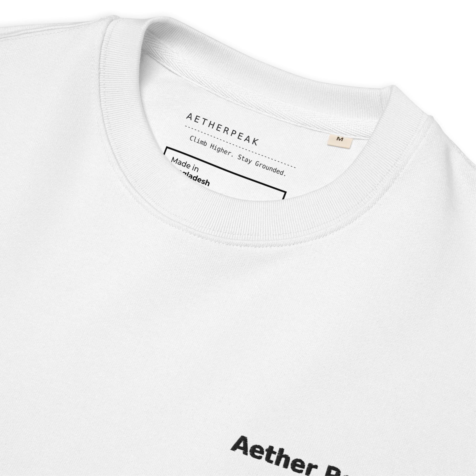 Close-up of a white t-shirt with 'Aetherpeak' branding and text on the collar.