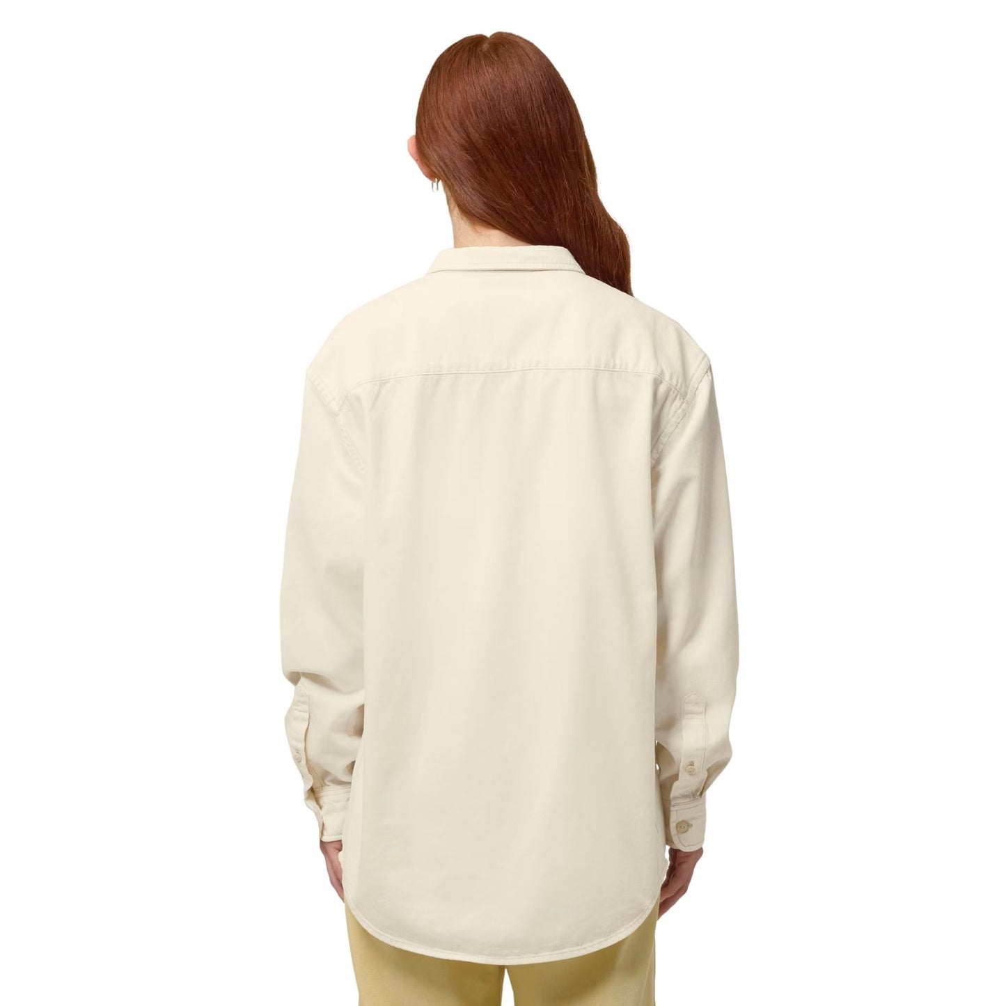 A woman wearing the Desert Dust  overshirt, standing with her back to the camera on a white background