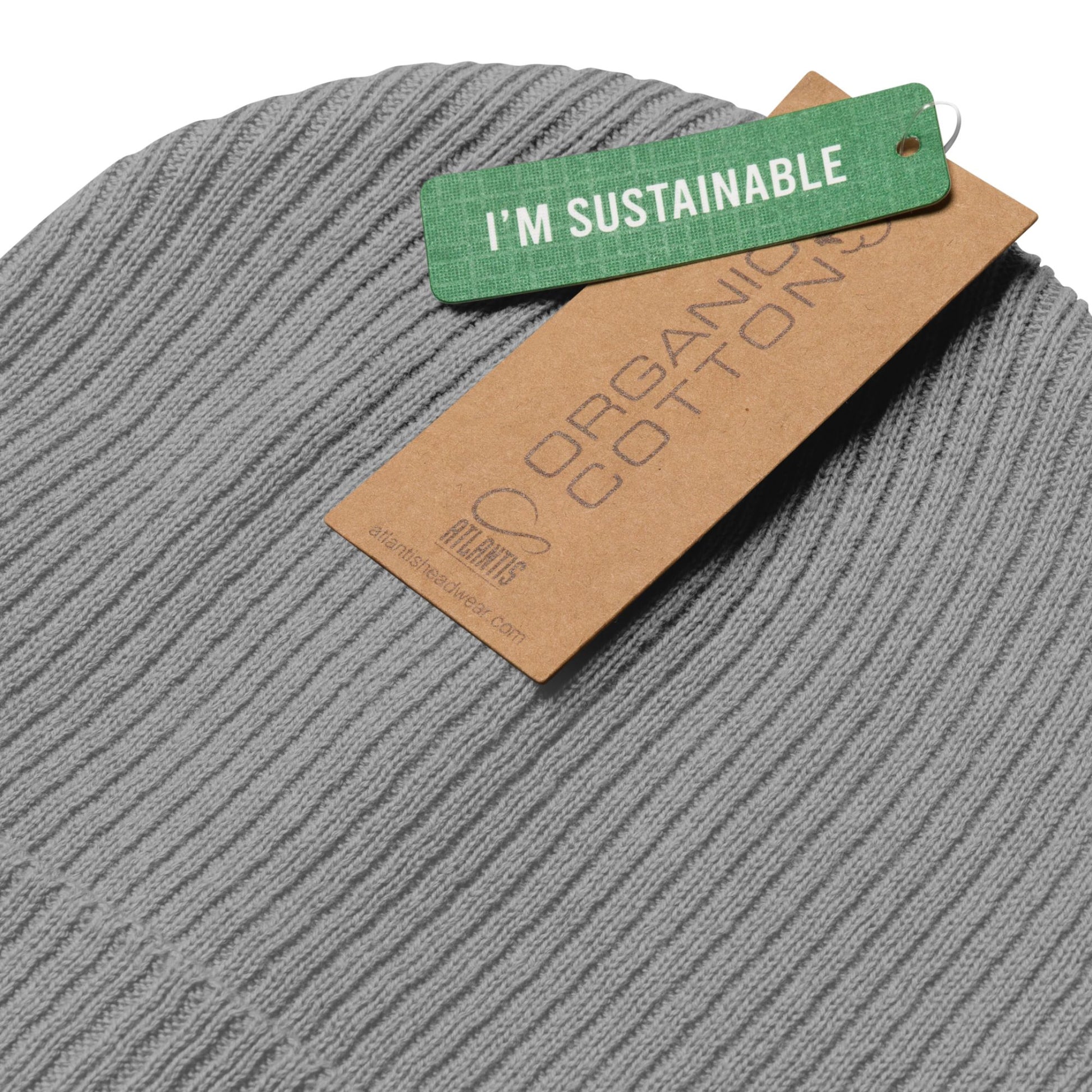Grey beanie with a green 'I'm Sustainable' tag and brown 'Organic Cotton' tag on a white background