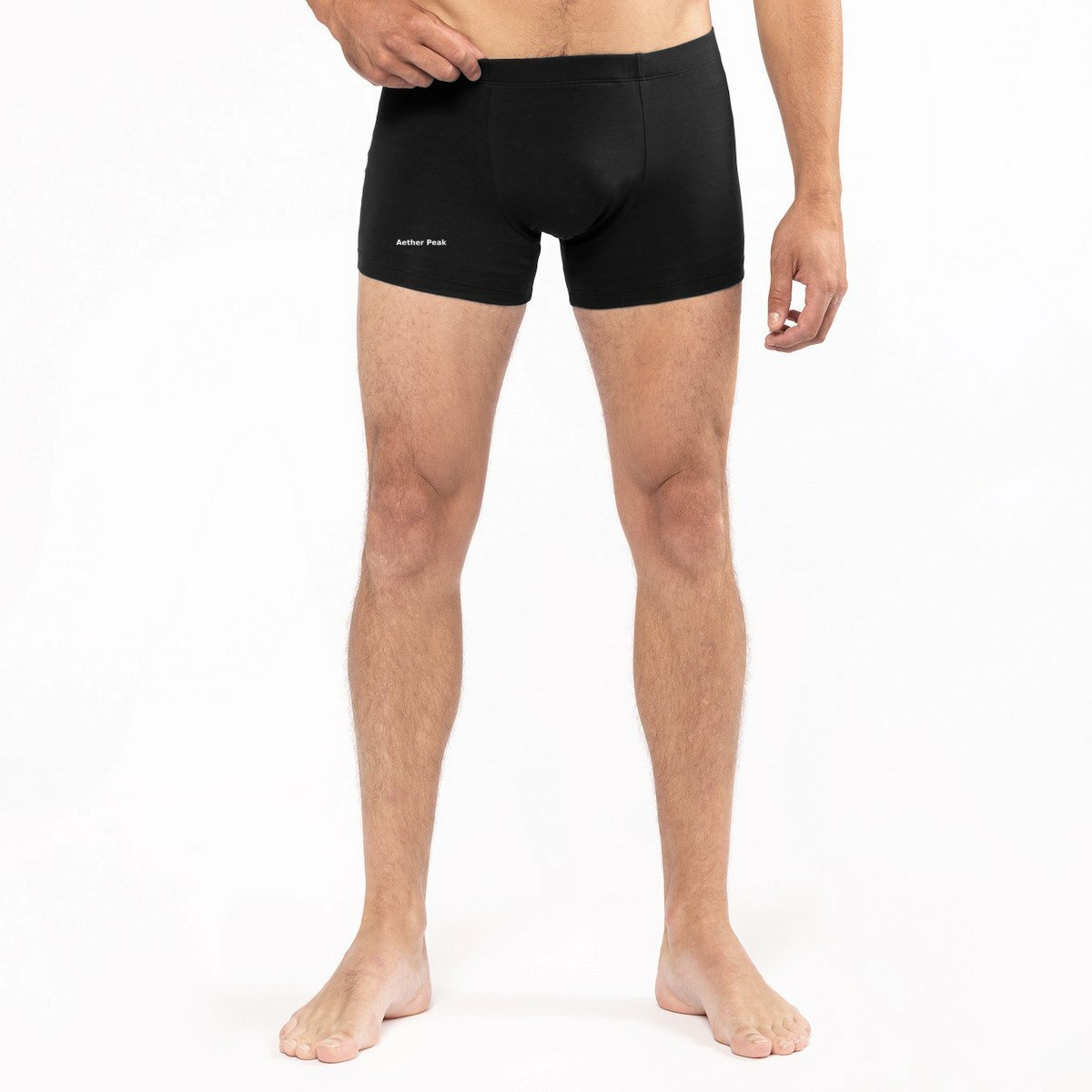 Male model wearing black Aether Peak boxer briefs on a white studio background.